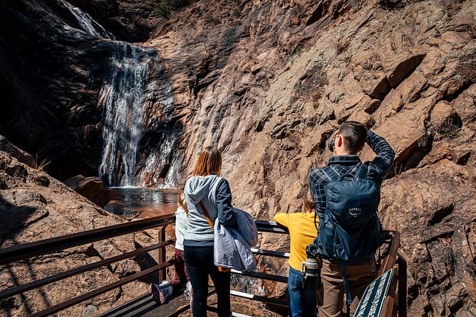 Visitors snap photos of the falls from a platform.