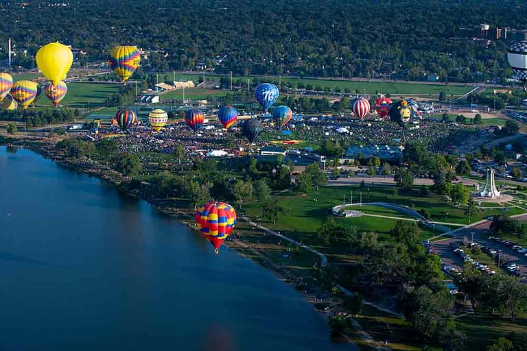 Hot air balloons floating over lake for Labor Day Liftoff