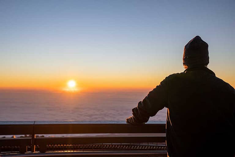 Man watching the sunrise on top of Pikes Peak