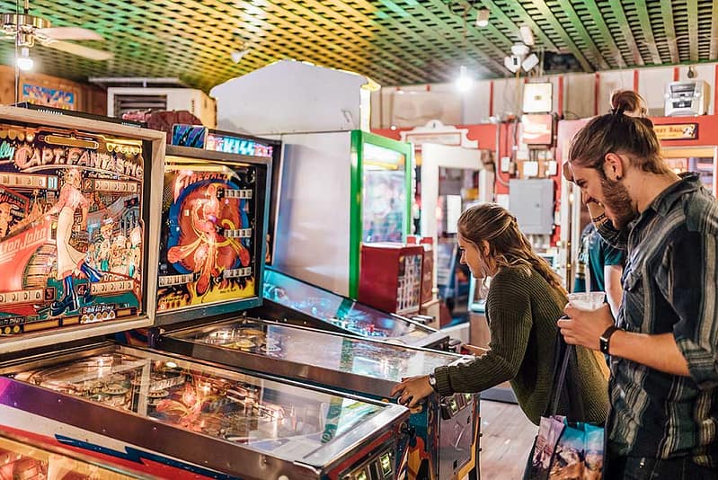 Couple playing pinball at Manitou Springs arcade