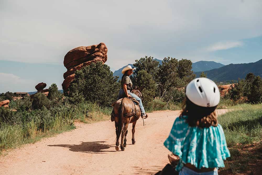 Little girl and guide horseback riding with Academy Riding Stables