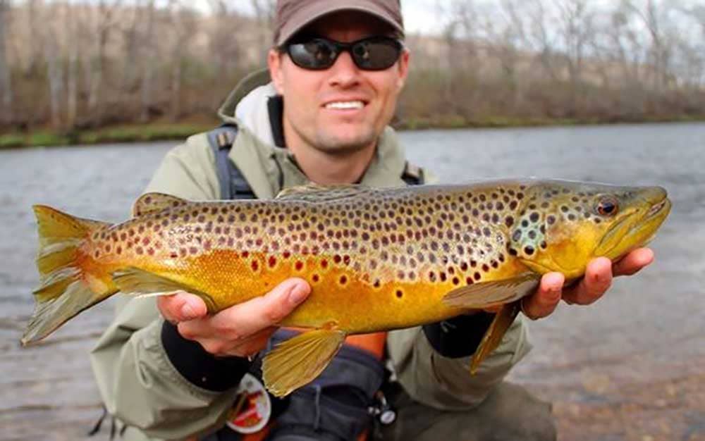 Man holding fish by the Arkansas River