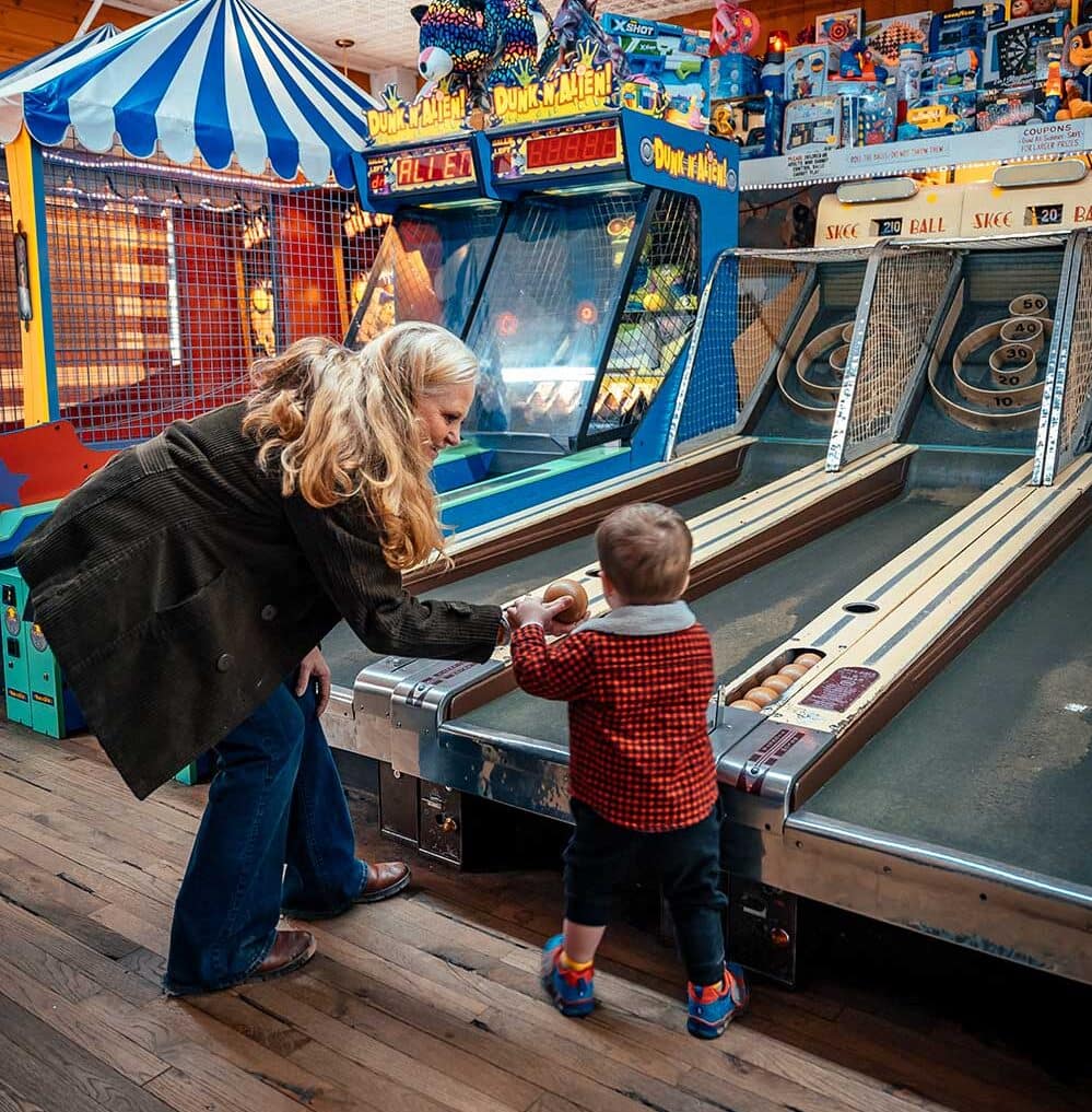 Little kid and grandma playing Skeeball at the Manitou Springs Arcade
