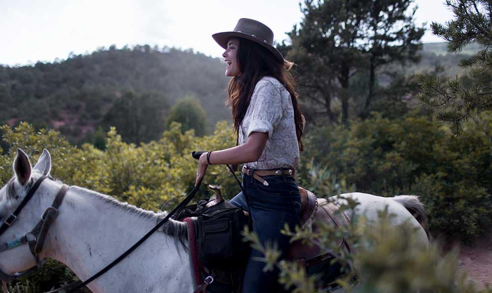 Woman riding Academy Riding Stables horse in Garden of the Gods