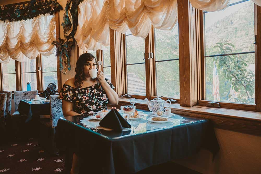 Woman drinking tea in Miramont Castle tearoom