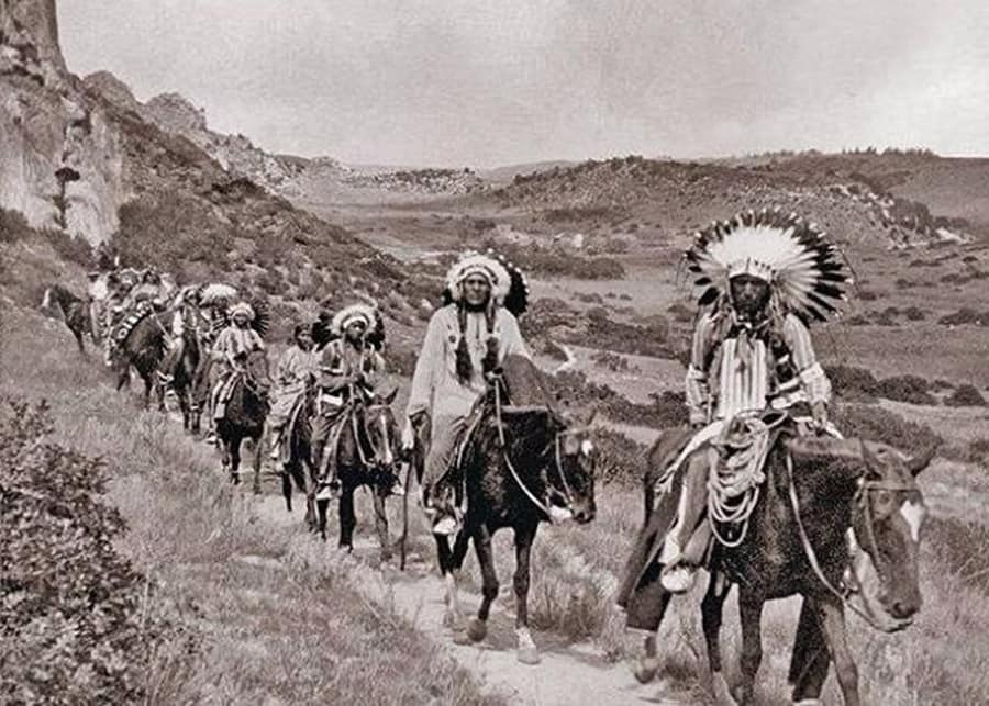 Native Americans on horseback riding through the Garden of the Gods.