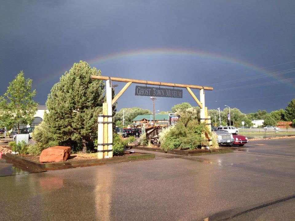 Front sign for Ghost Town Museum with a rainbow over it