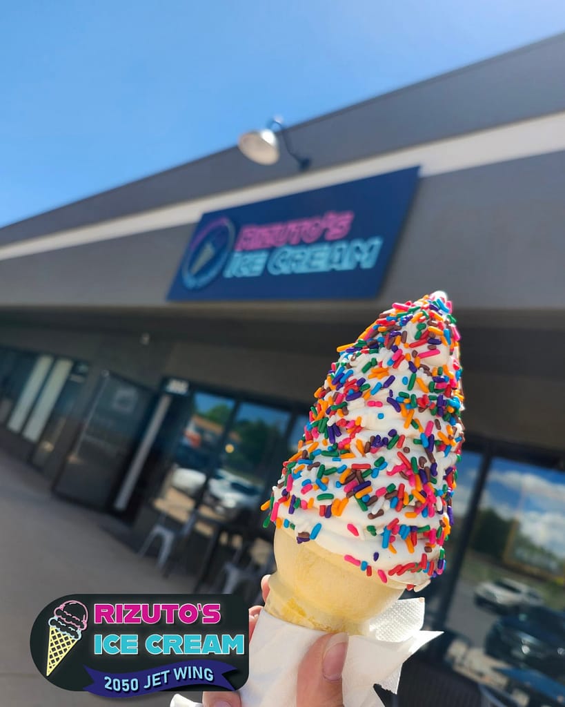 Una persona con un cucurucho de helado a la puerta de la heladería Rizuto's Ice Cream, en Colorado Springs
