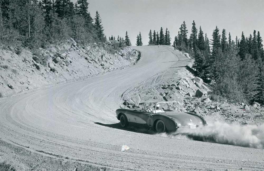 A race car ascends a gravel curve during the 1900s Pikes Peak International Hill Climb.