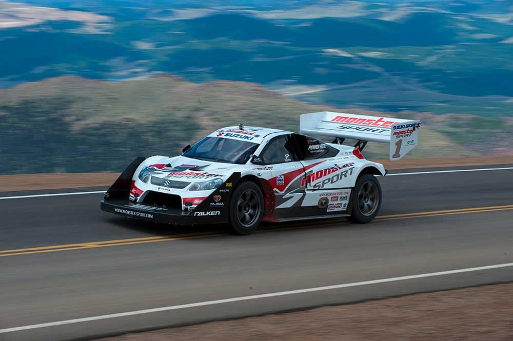 A modern race car speeds along on Pikes Peak Highway.