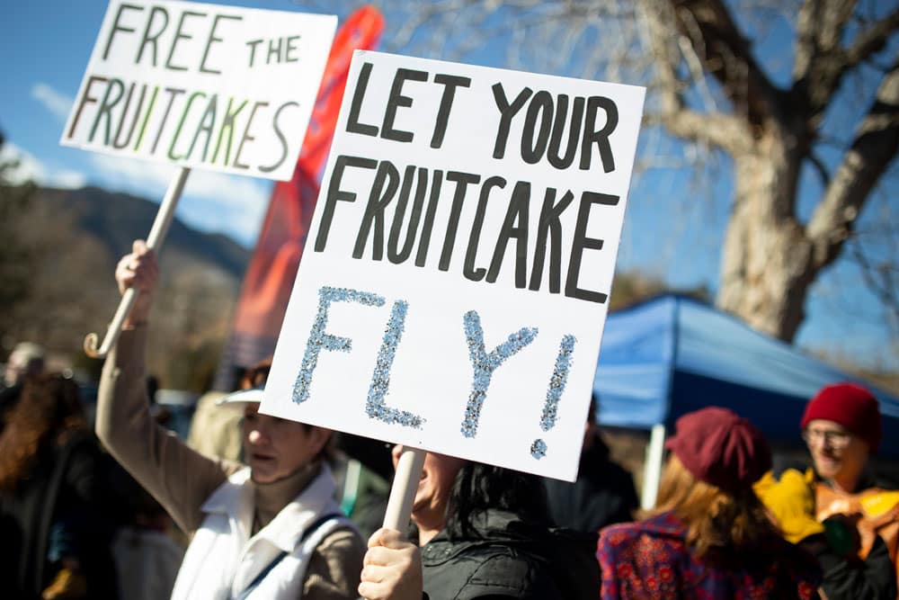 Sosteniendo carteles en el Gran Lanzamiento de Pastel de Frutas de Manitou Springs