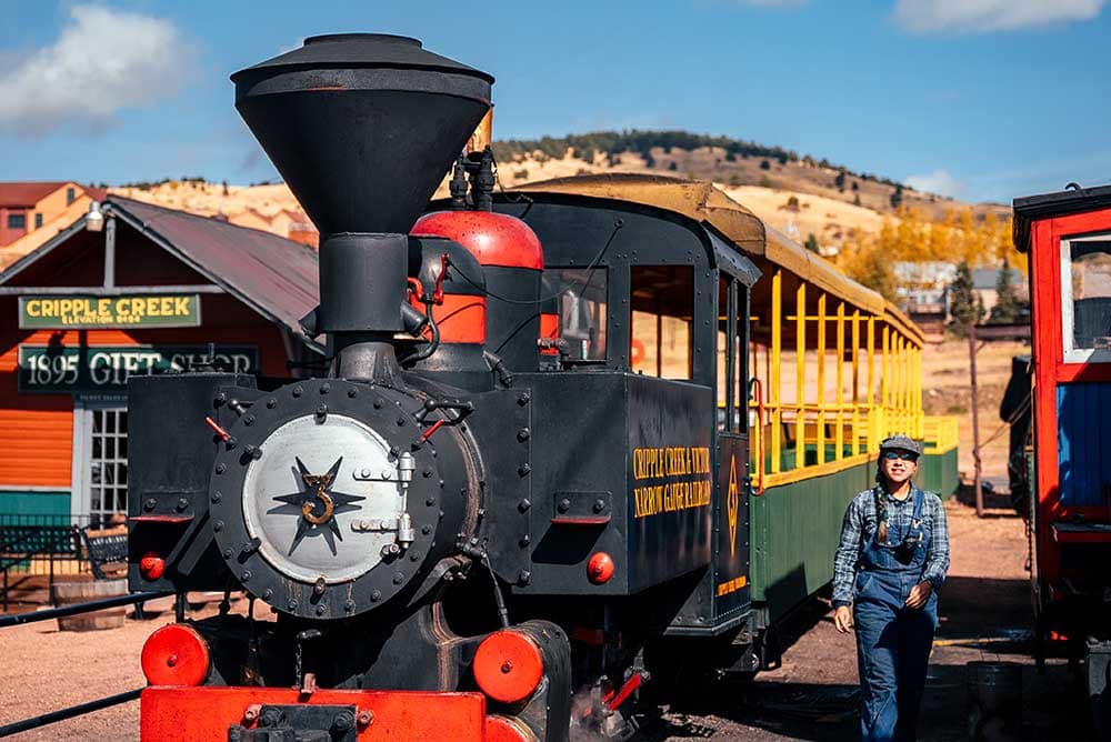 A train conductor walks alongside the Cripple Creek and Victor Narrow Gauge Railroad at the train depot.