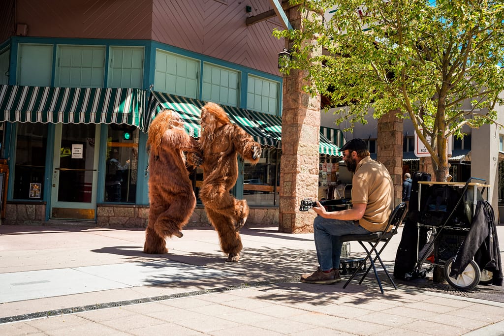 Bigfeet dancing while a street performer plays guitar in Manitou Springs
