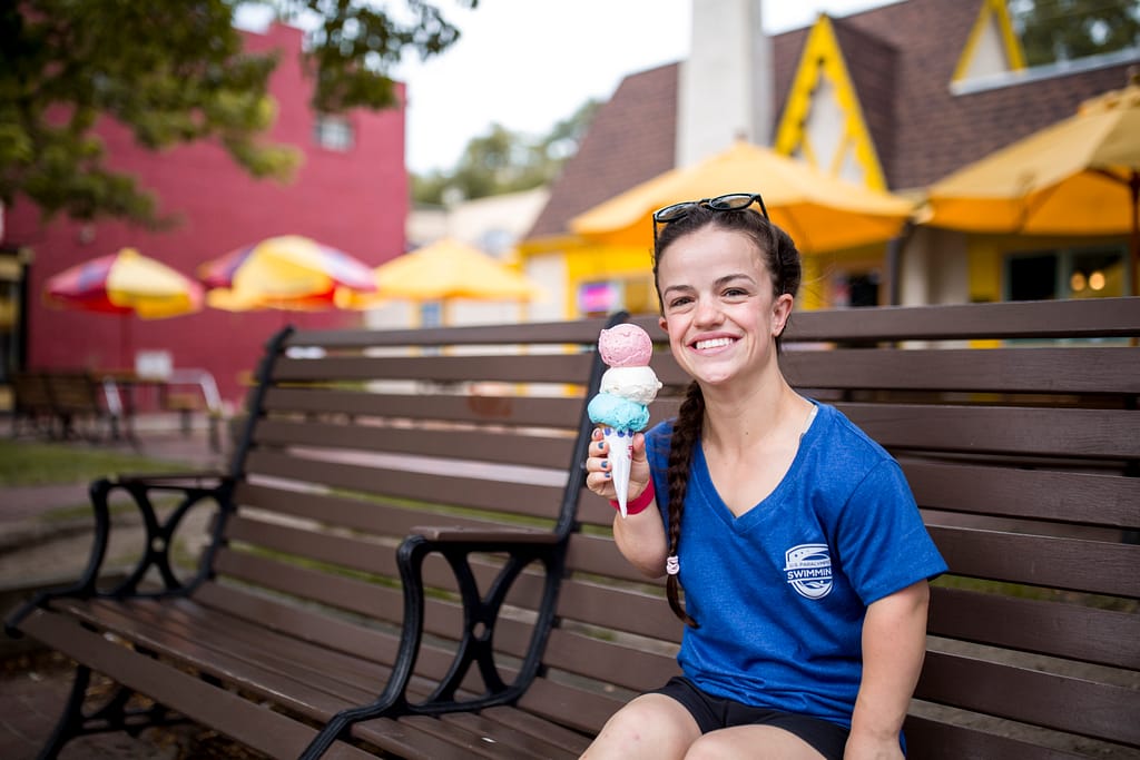 Woman sitting on bench holding ice cream in front of the Colorado City Creamery in Old Colorado City
