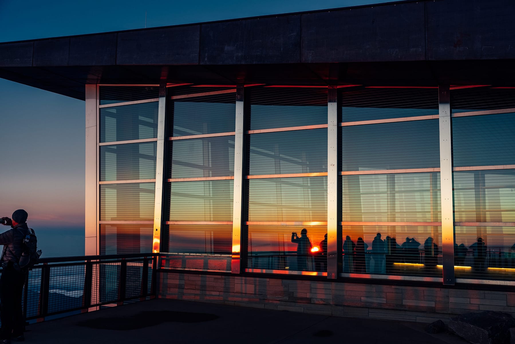 El amanecer reflejándose en las ventanas del Centro de Visitantes de la Cima de Pikes Peak