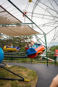 Little boy on a spinning ride at the North Pole - Santa's Workshop