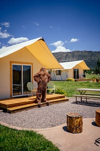 Bigfoot standing on the deck of an Echo Canyon River Expeditions glamping tent