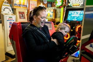 Mother and son playing a racing game at the Manitou Springs Arcade