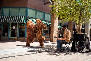 Bigfeet dancing while a street performer plays guitar in Manitou Springs