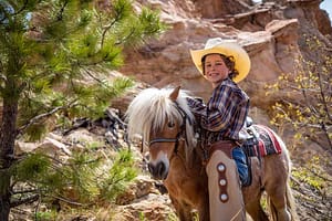 A child pets a pony at the Flying W Ranch.