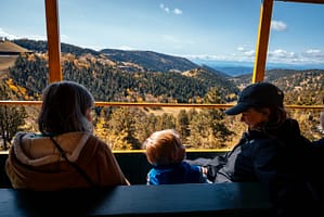 mother, child, and grandmother on an open car train in Cripple Creek