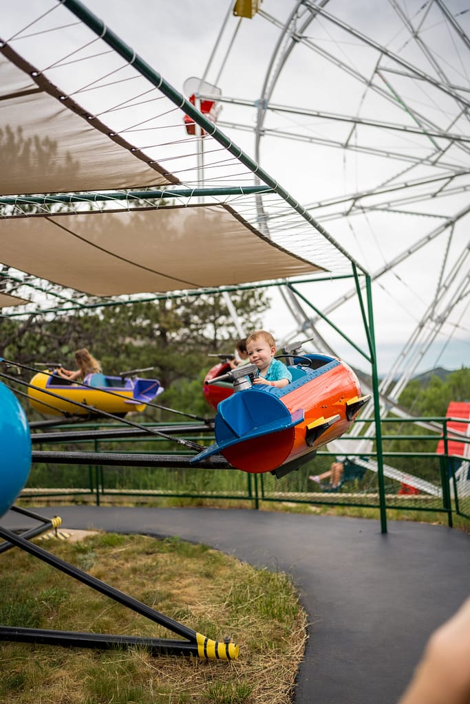 Little boy on a spinning ride at the North Pole - Santa's Workshop