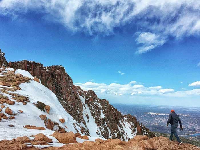 A person takes a photo of one of Pikes Peak's sweeping views.